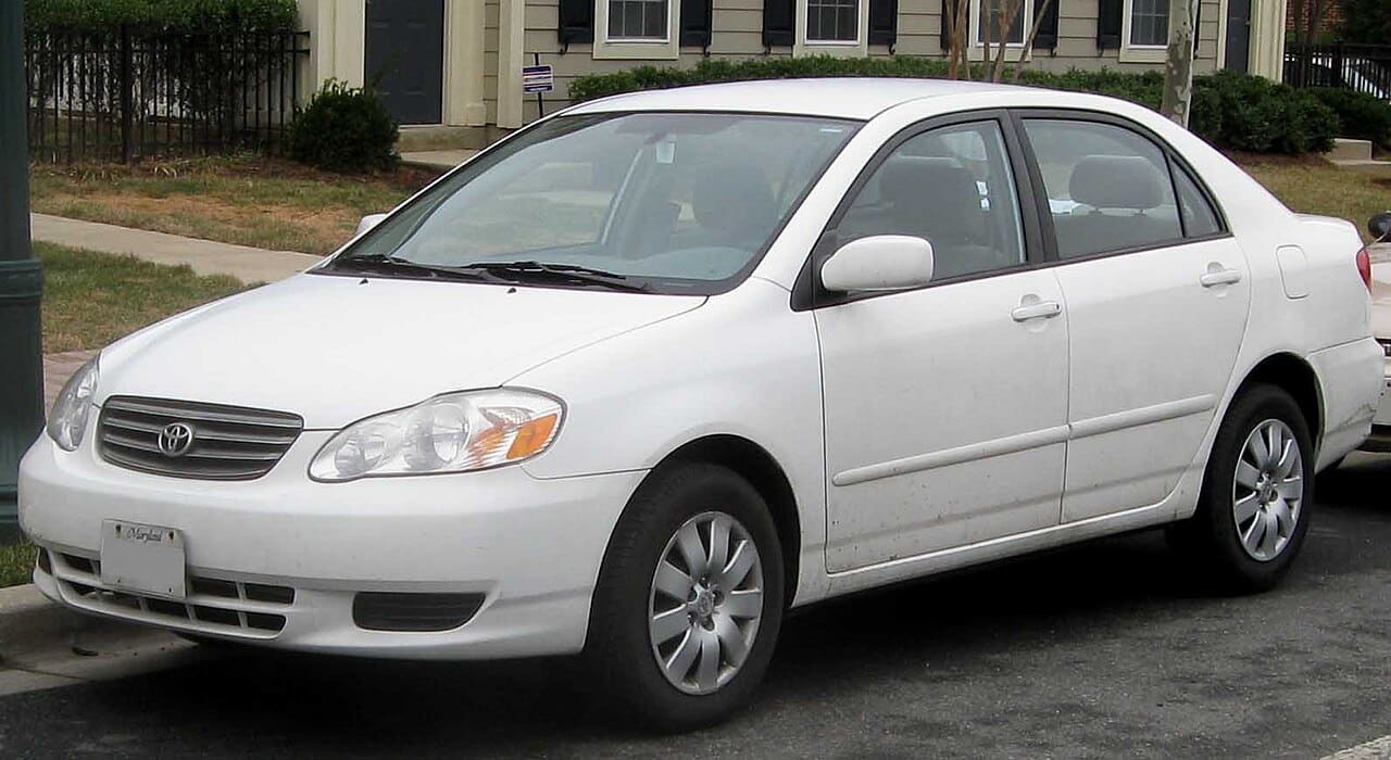 White 2003 to 2004 Toyota Corolla LE sedan parked on a residential street