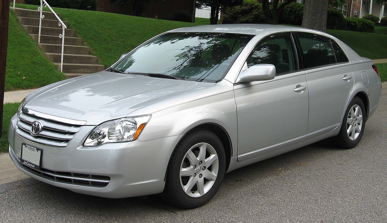 Silver 2005 to 2007 Toyota Avalon sedan parked along a residential street
