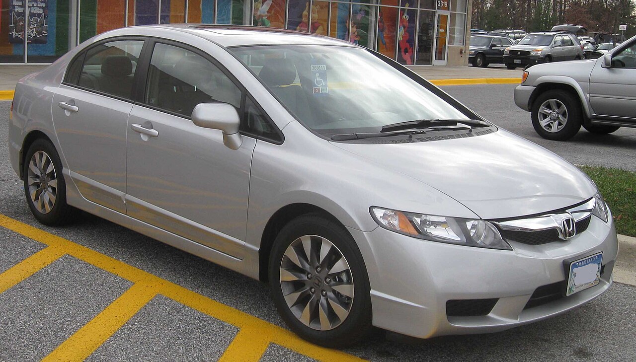 Silver 2009 Honda Civic EX sedan parked in a shopping center lot