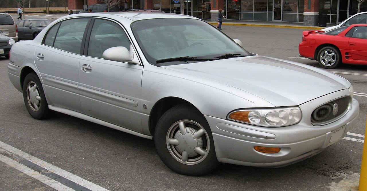 Silver 2000 to 2005 Buick LeSabre Custom sedan parked in a shopping center