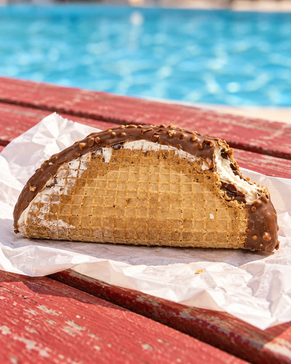 Choco Taco on an opened wrapper beside a swimming pool