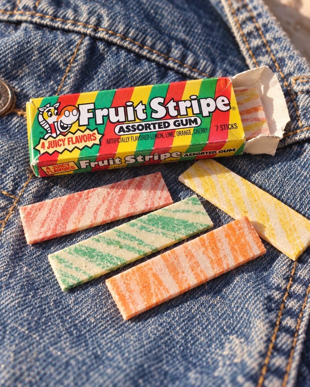 Fruit Stripe gum pack and colorful striped sticks on a denim jacket