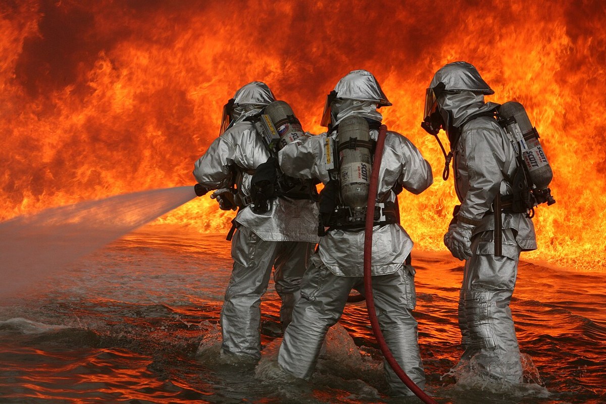 Aircraft rescue firefighters work together during a live-fire training exercise