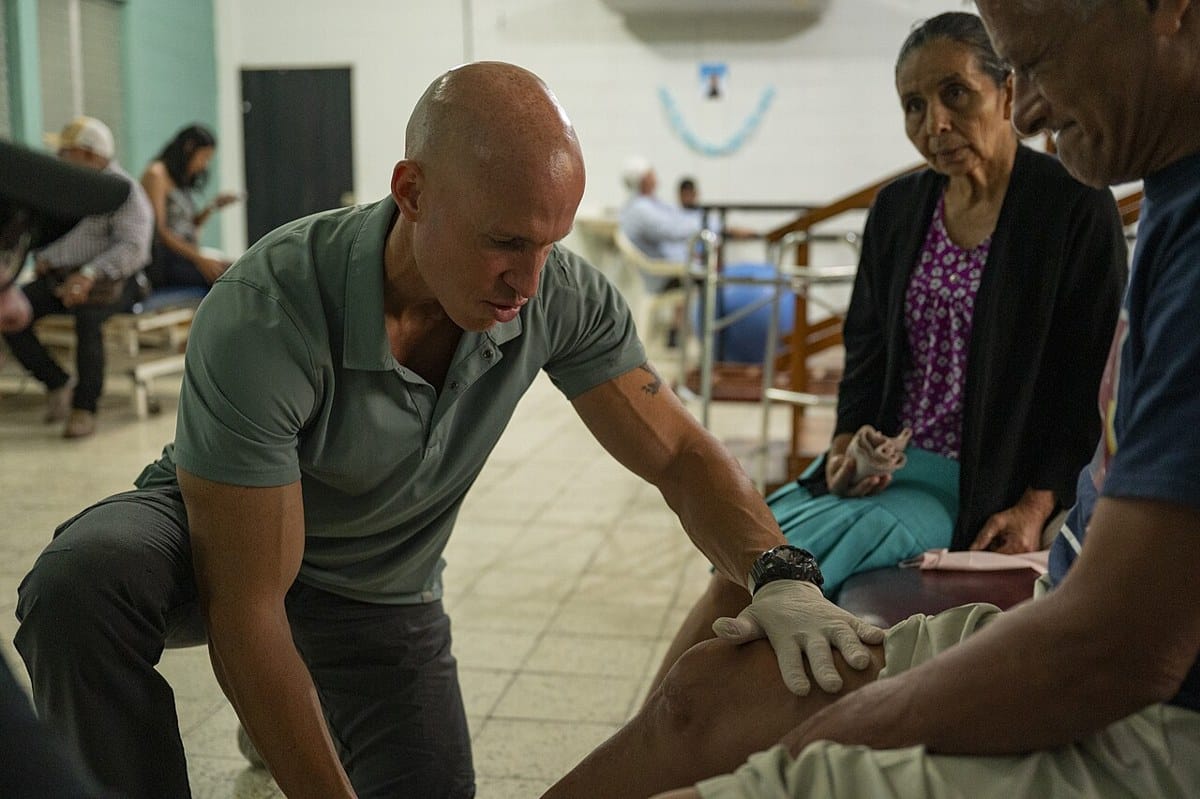 Physical therapist examines a patient’s leg during a rehabilitation appointment in Honduras
