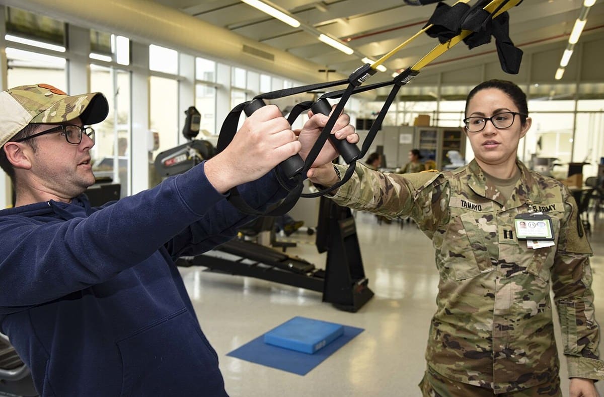 Occupational therapist guides a patient through a hand-strength exercise at Landstuhl