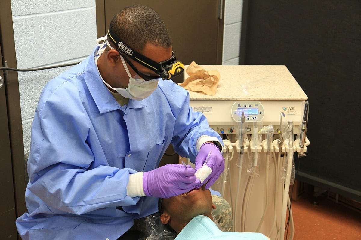 Dental hygienist provides patient care during Southern Care 2014