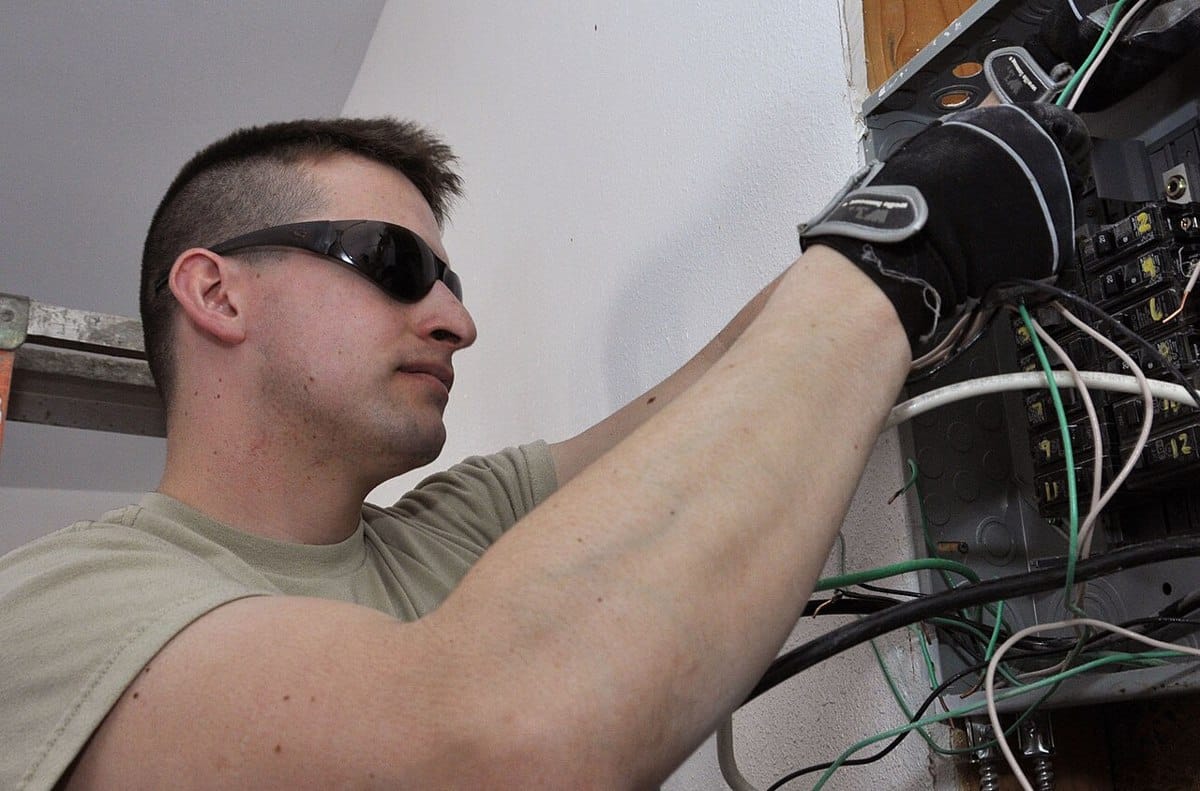 Electrician working on wiring inside an electrical panel