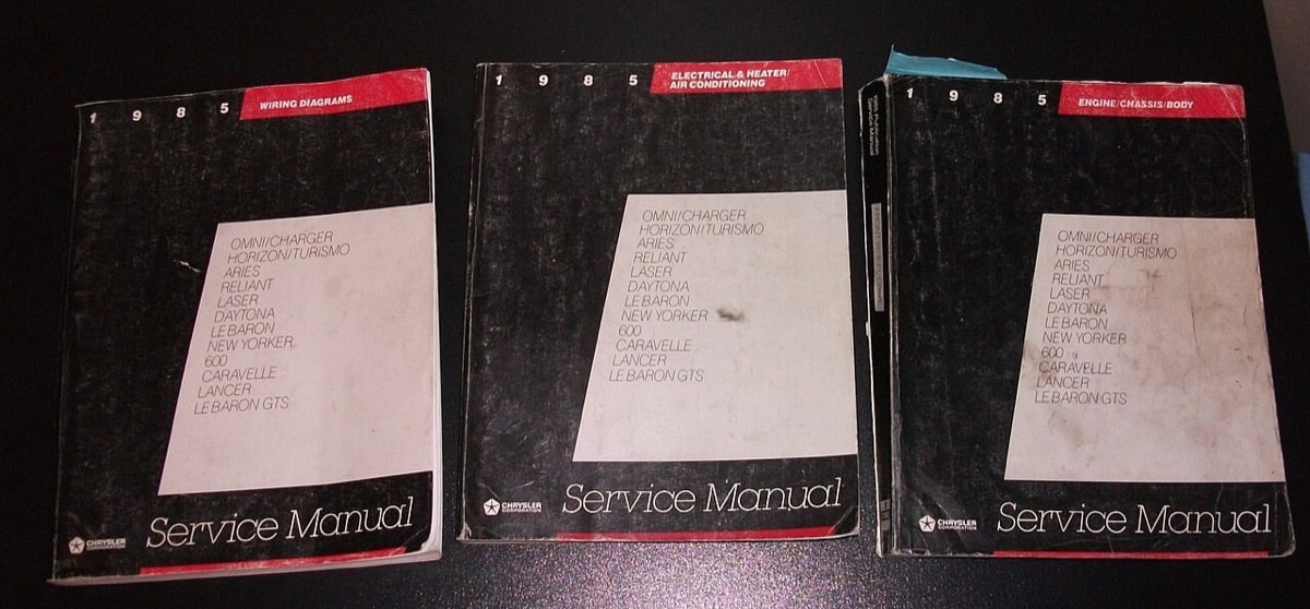 Three worn 1985 Chrysler factory service manuals for wiring, electrical systems, and chassis repairs