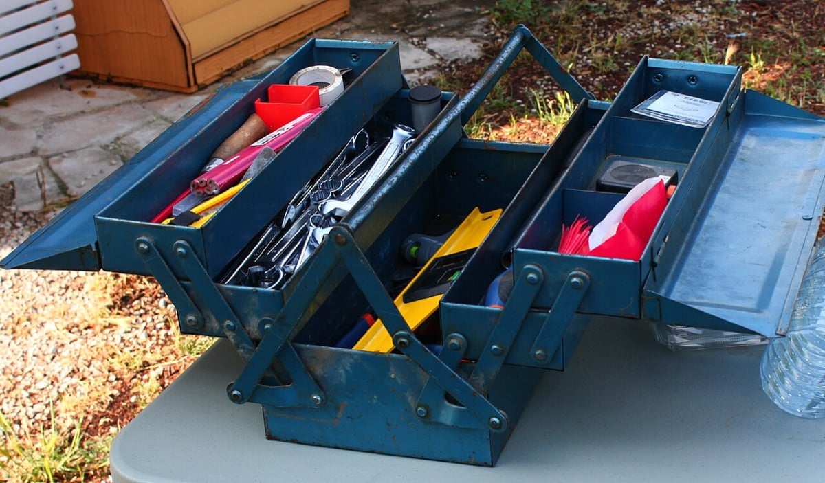Open blue metal cantilever toolbox filled with hand tools
