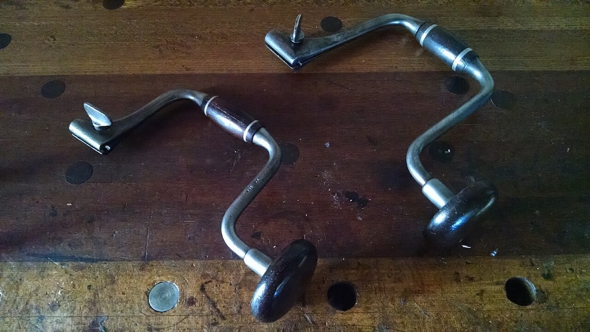 Two Spofford-style hand braces on a wooden workbench