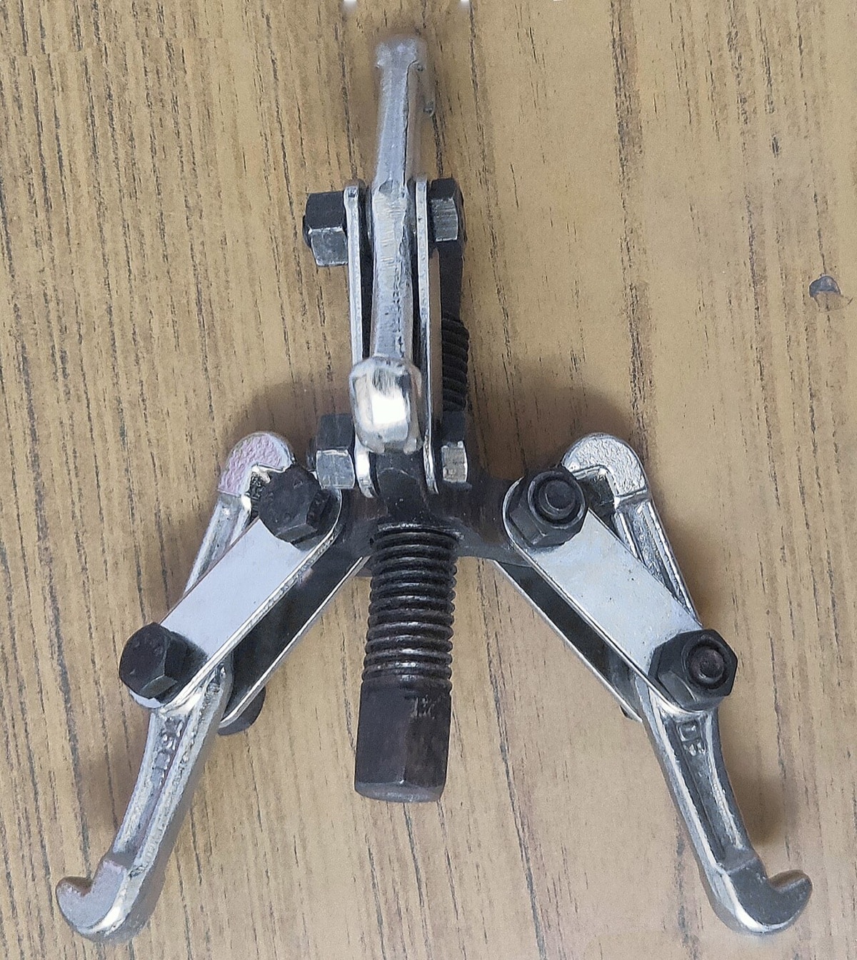 Three-jaw bearing puller with a central forcing screw