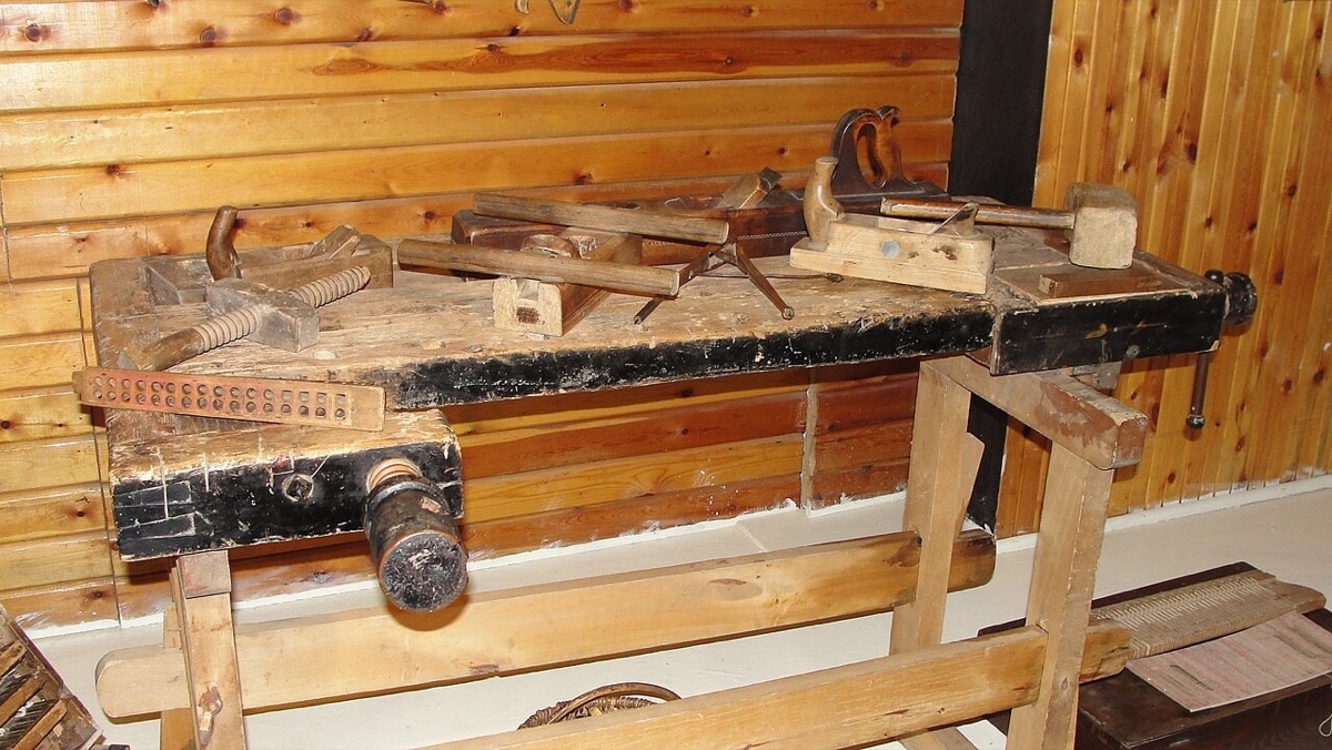 Worn wooden workbench with vises and traditional hand tools at the Zaslavl museum