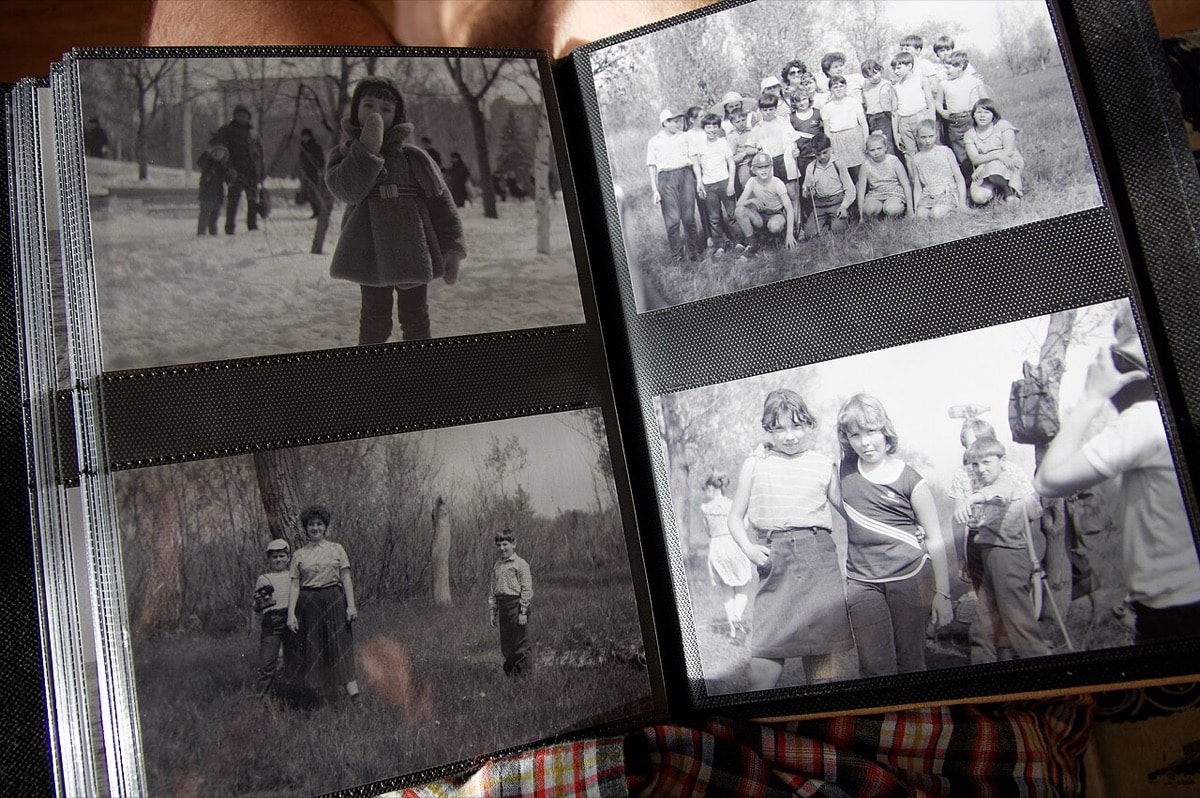 Open family photo album holding black-and-white photographs