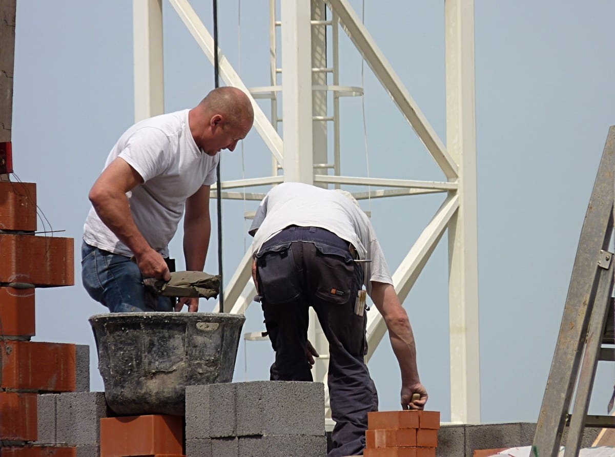 Masons laying brickwork at a construction site in Belgium
