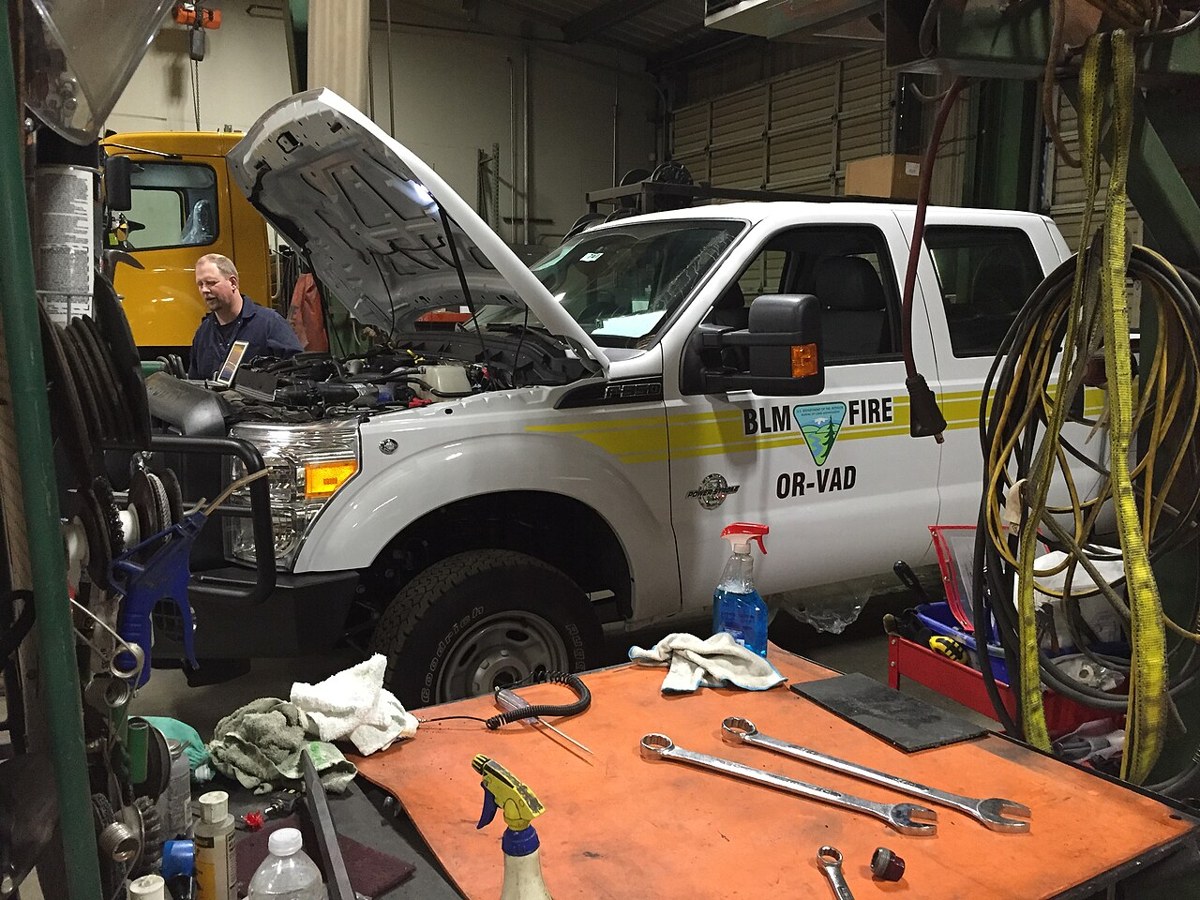 Mechanic inspecting a BLM fire vehicle in an Oregon workshop