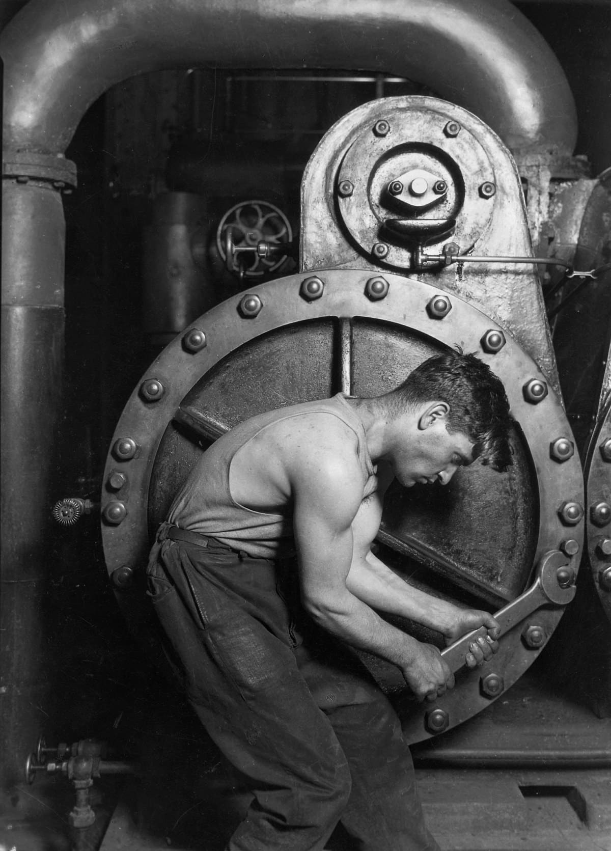 Lewis Hine photograph of a mechanic working on a steam pump in 1920