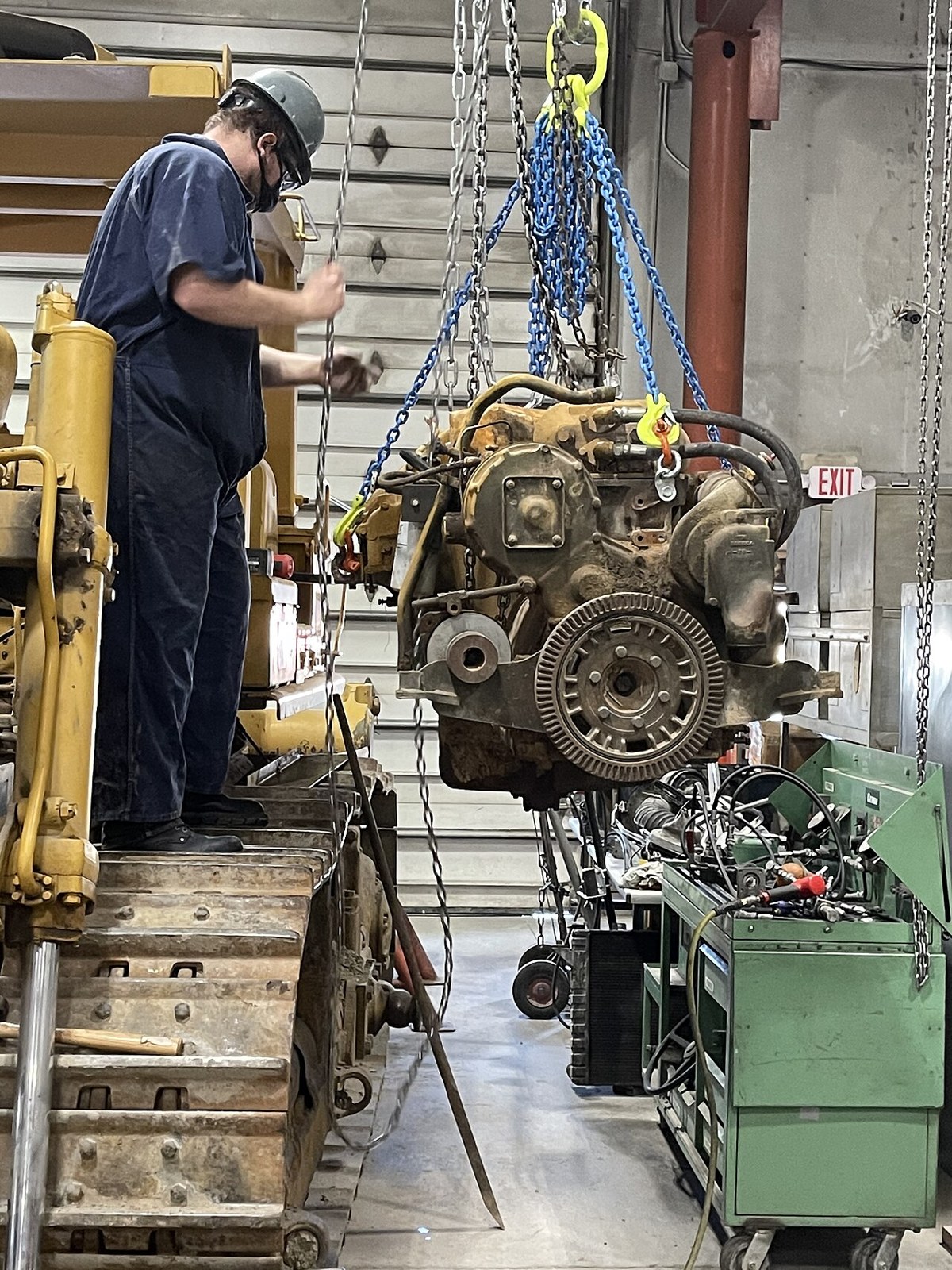 Job Corps trainee working on an engine suspended from a hoist