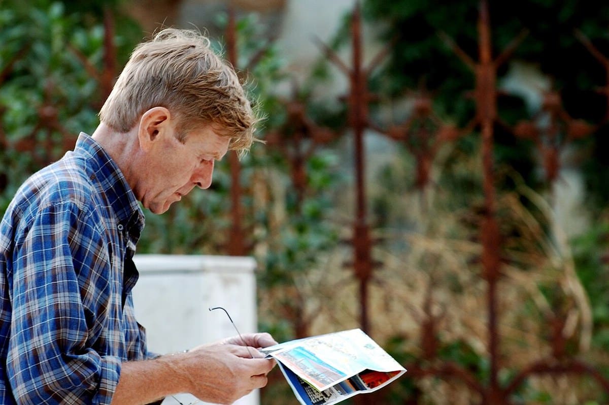 Man studying a folded paper map outdoors