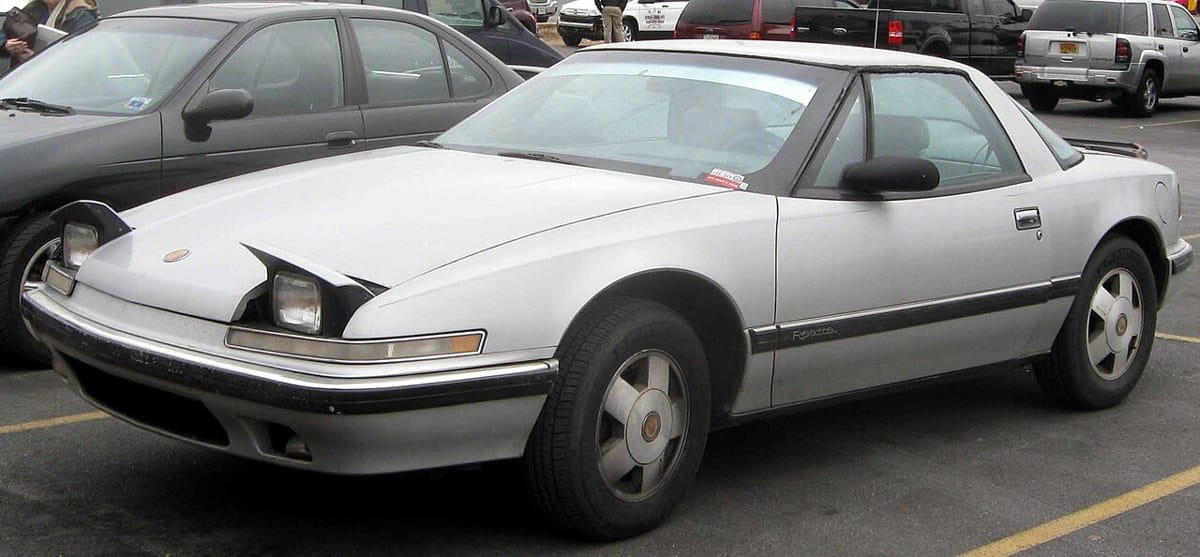 Silver Buick Reatta coupe with its headlights raised