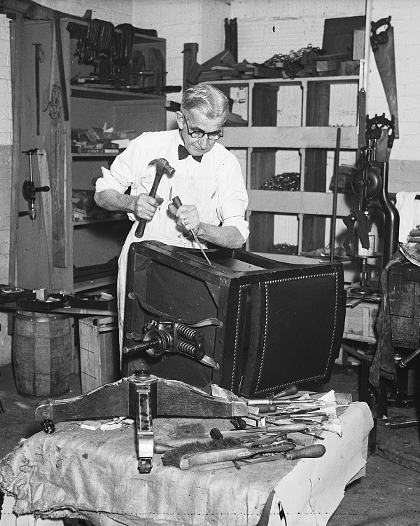 A chair being repaired at a workbench, around 1936.