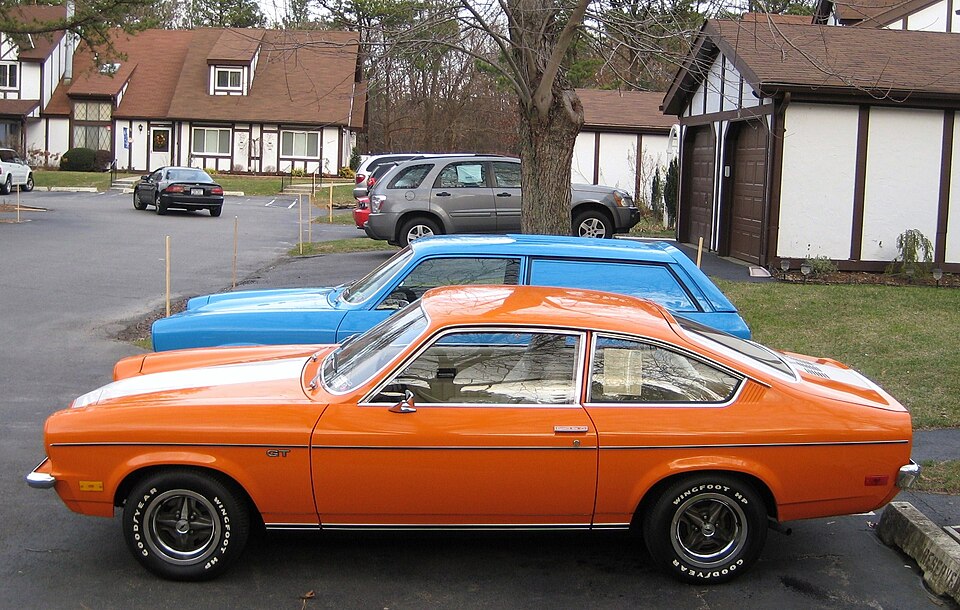 Orange 1973 Chevrolet Vega GT beside a blue 1971 Vega Panel Express